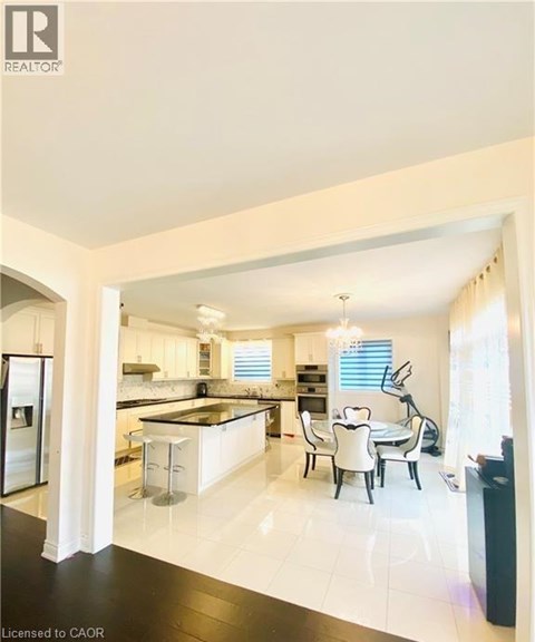 A modern kitchen with white cabinets and black countertops.