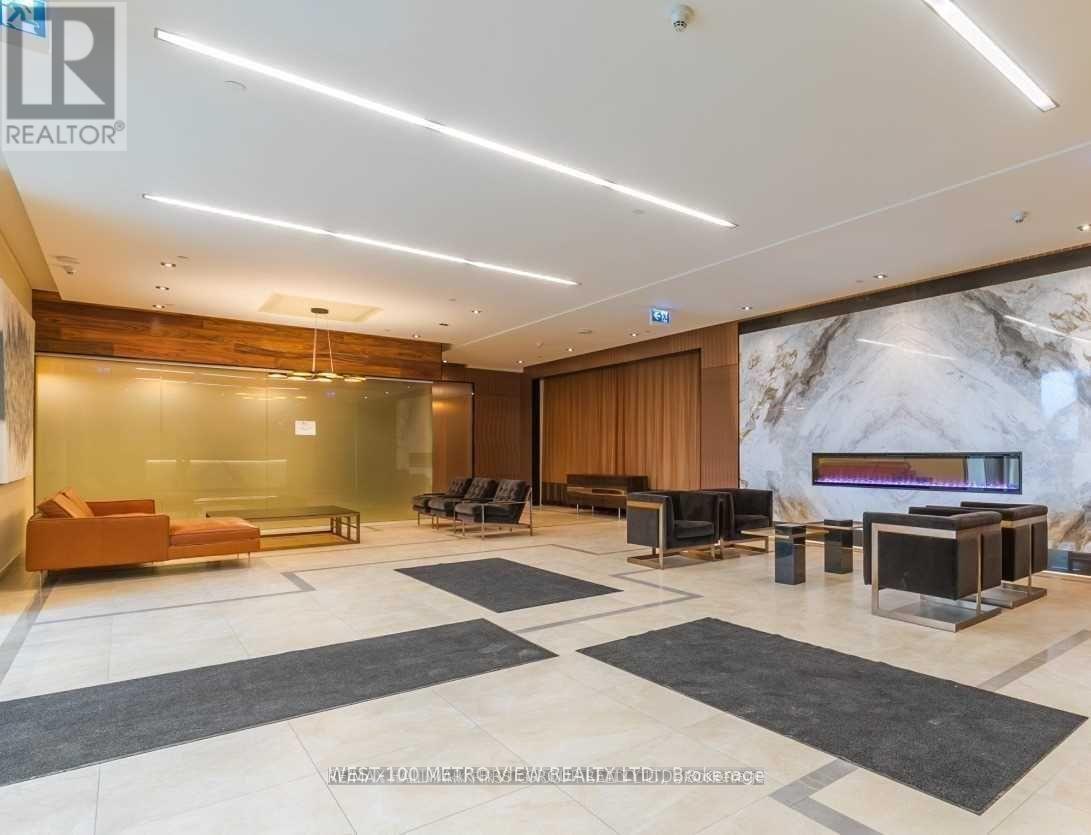 A spacious lobby with a marble wall and a wooden door.