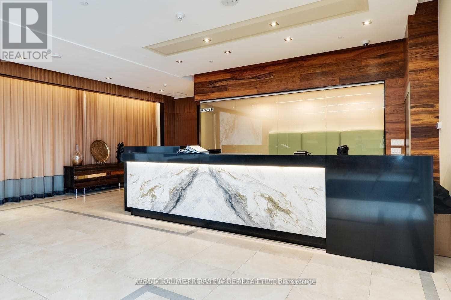A reception area with a marble counter and a wooden wall.