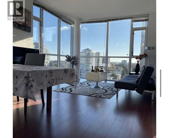 A living room with a large table and a view of the city.