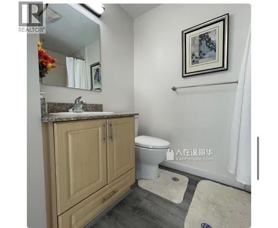 A bathroom with a toilet, sink, and a mirror.