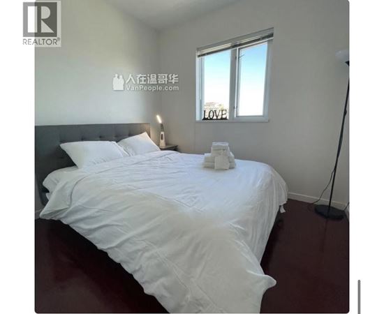 A bedroom with a large bed and a window with the word LOVE written on it.