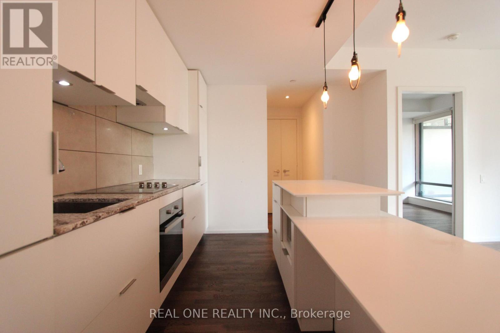A modern kitchen with white cabinets and a marble countertop.
