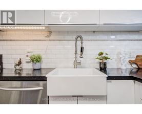 A modern kitchen with a white sink and a stainless steel dishwasher.