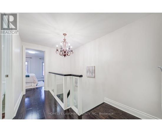 A well-lit, spacious room with a chandelier and a framed picture on the wall.