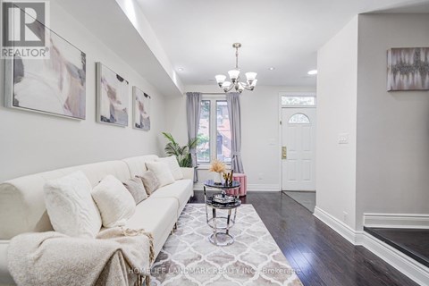 A well-lit living room with a white sofa and a chandelier.