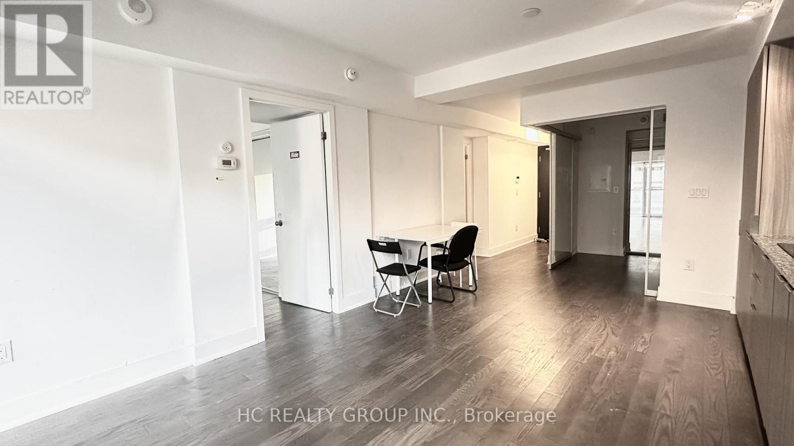 A spacious room with a dining table and chairs.