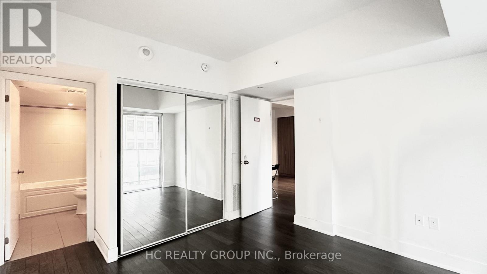 A white room with a sliding glass door leading to a bathroom.