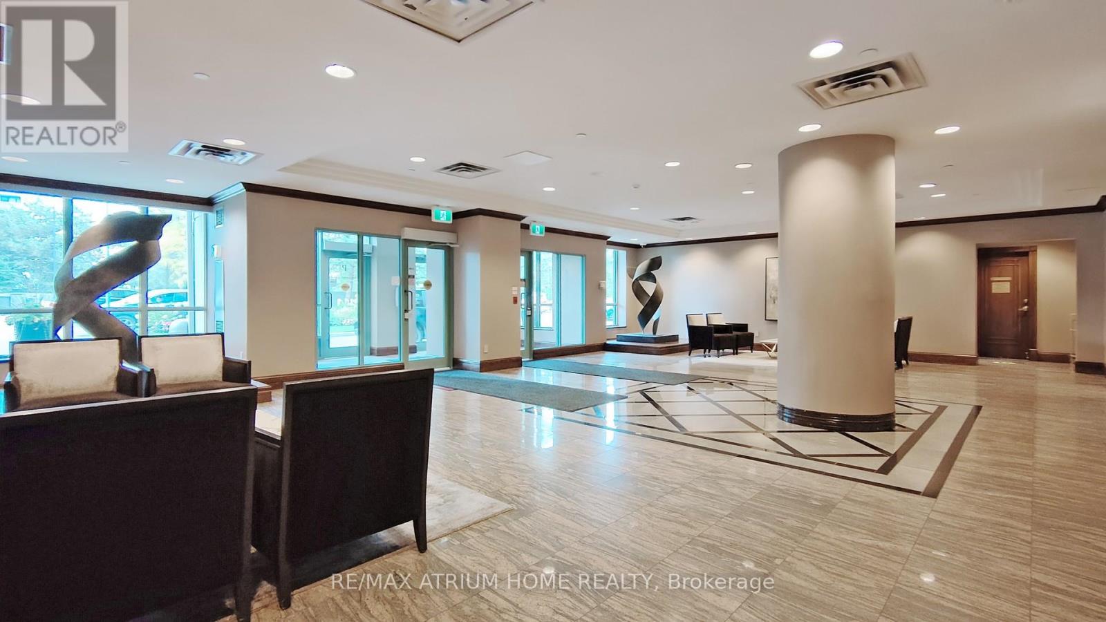 A spacious lobby with a large sculpture and a reception desk.