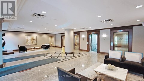 A spacious living room with a black couch and a coffee table.