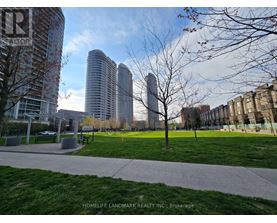 A park with a grassy area and a bench in front of a building.