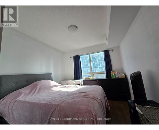 A bedroom with a bed, nightstand, and window.