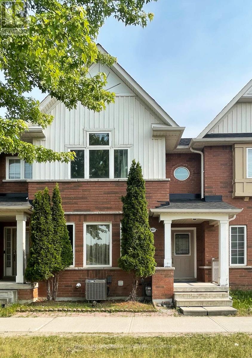 A house with a white siding and a brick facade with a small front porch.