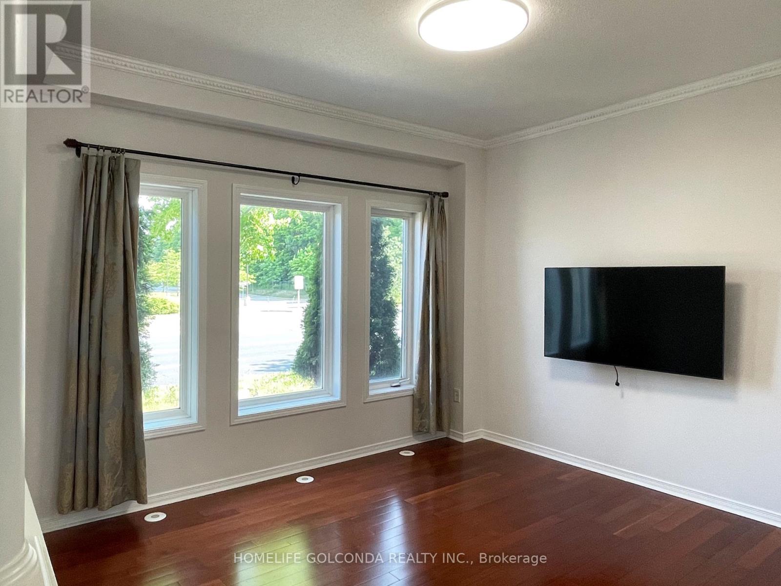 A room with a flat screen TV mounted on the wall and a sliding glass door.