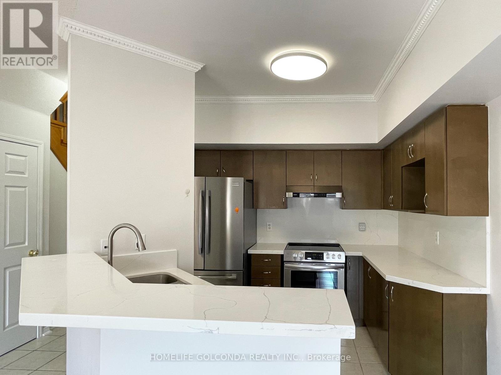 A kitchen with a white counter top and stainless steel appliances.