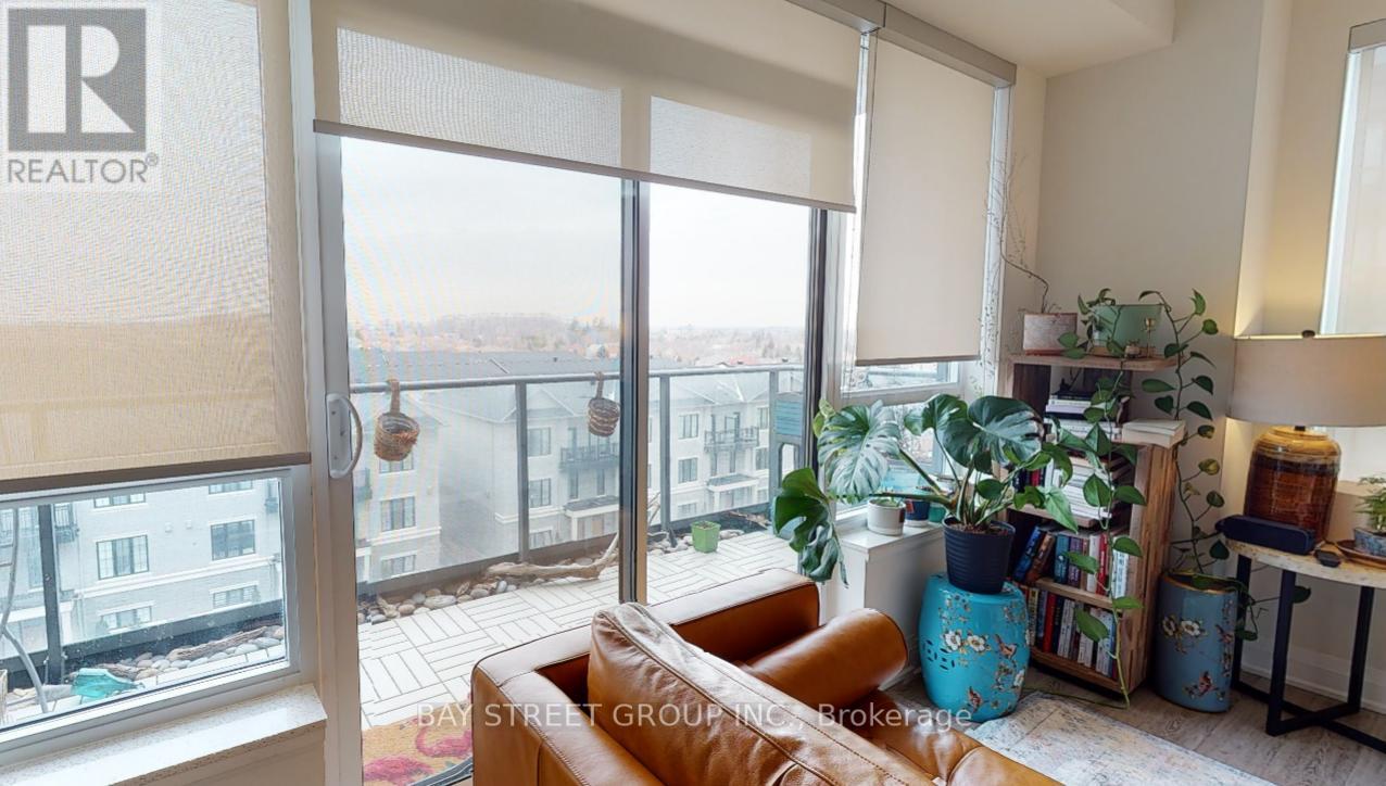 A living room with a brown leather couch and a large window overlooking a cityscape.