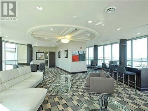 A living room with a white couch and a glass coffee table.
