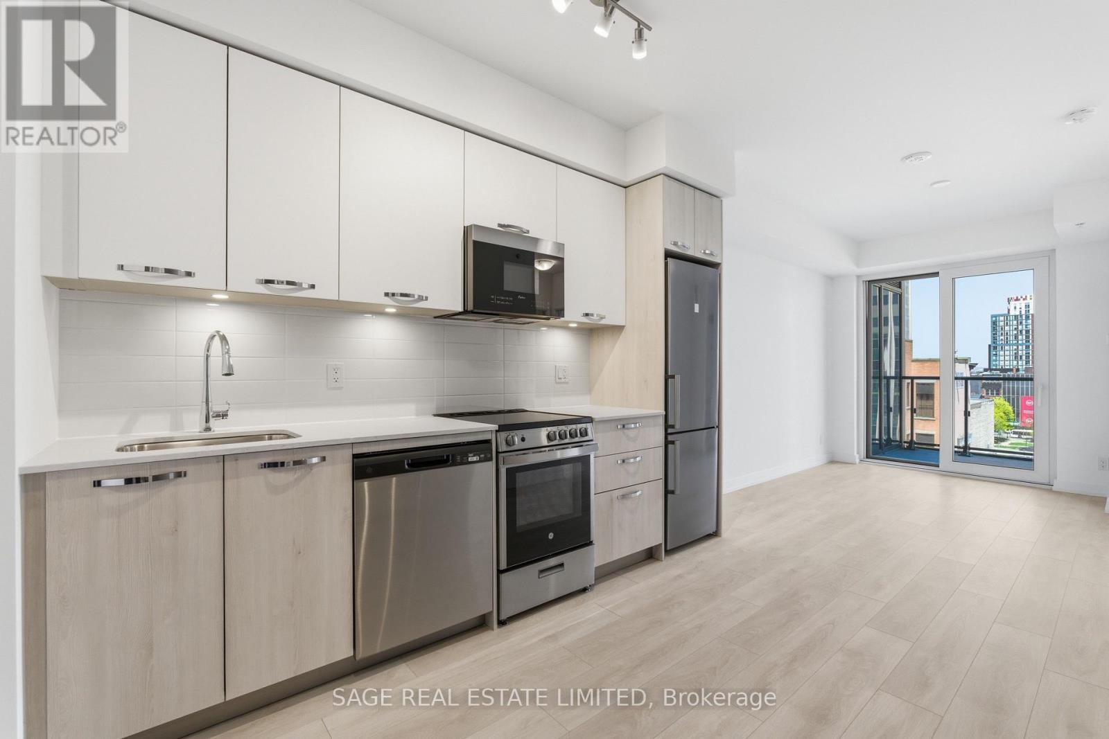 A modern kitchen with stainless steel appliances and wooden cabinets.