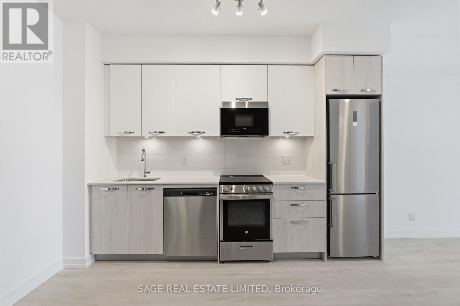 A modern kitchen with stainless steel appliances and white cabinets.