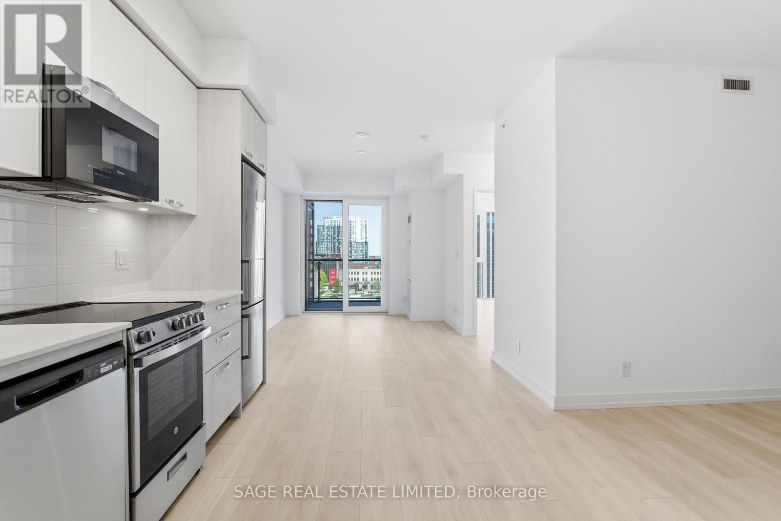 A white kitchen with a black microwave and stove.