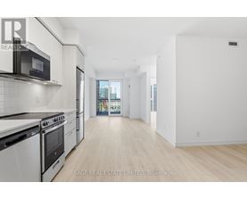 A white kitchen with a black microwave and stove.