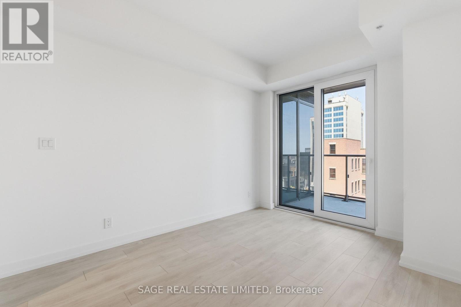 A white room with a sliding glass door leading to a balcony.