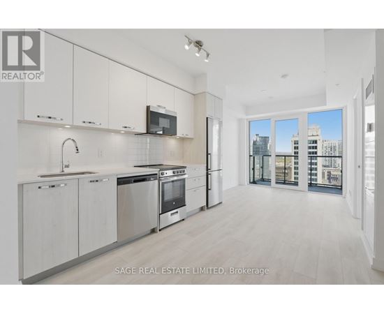 A modern kitchen with white cabinets and stainless steel appliances.