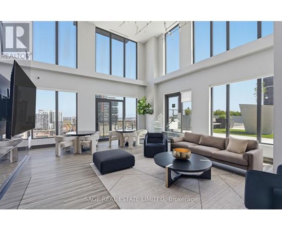 A living room with a black couch and a wooden floor.