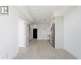 A spacious, empty room with white walls and wooden flooring.