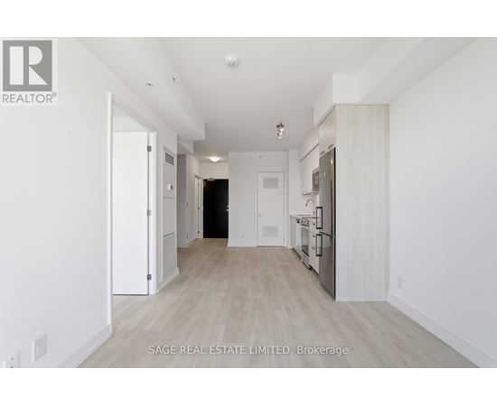 A spacious, empty room with white walls and wooden flooring.