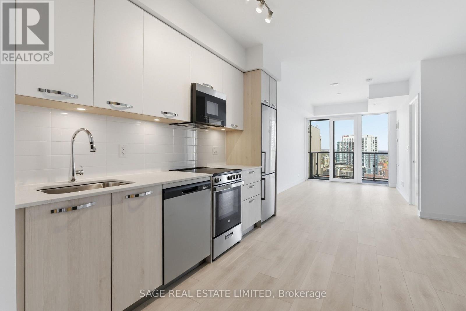 A modern kitchen with white cabinets and stainless steel appliances.