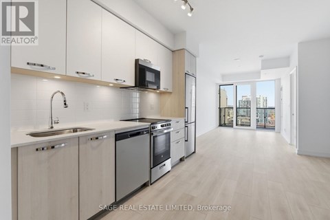 A modern kitchen with white cabinets and stainless steel appliances.