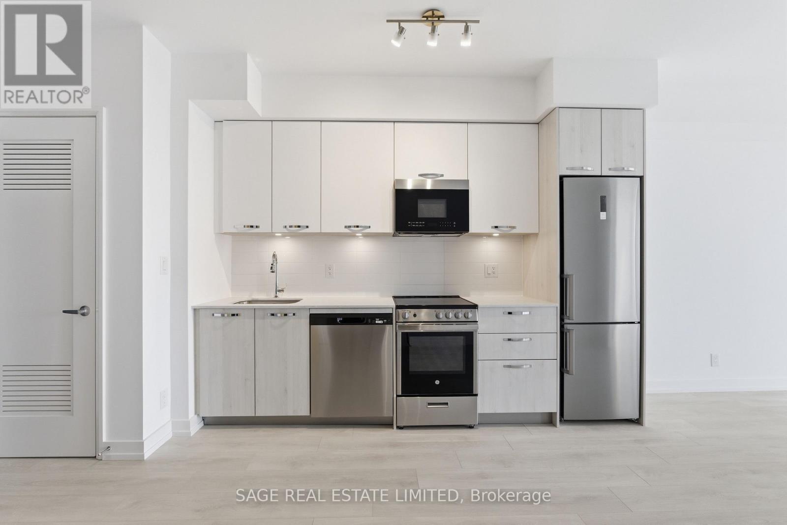 A modern kitchen with stainless steel appliances and white cabinets.