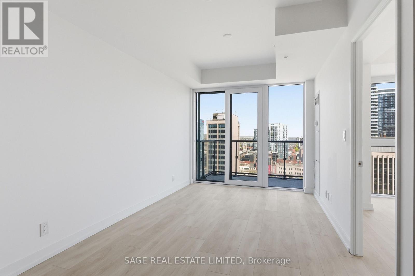A large, empty room with a view of the city through the windows.