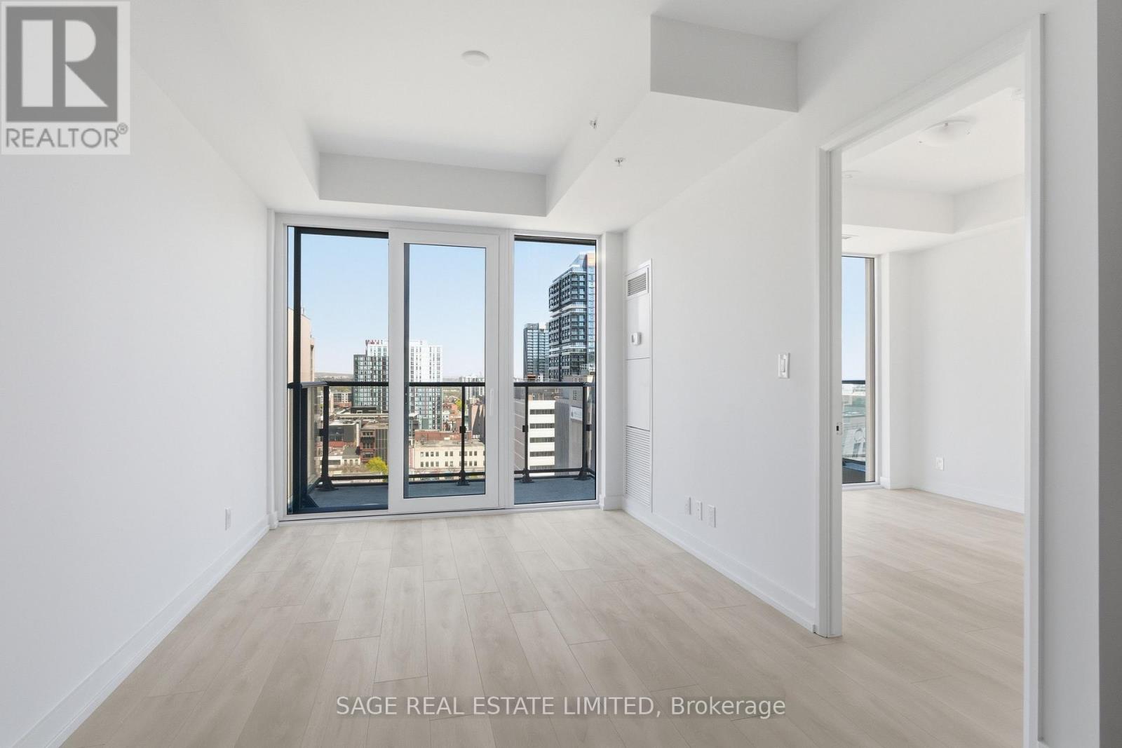 A spacious room with a view of the city through large windows.