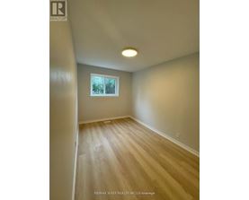 A room with a window and wooden flooring.
