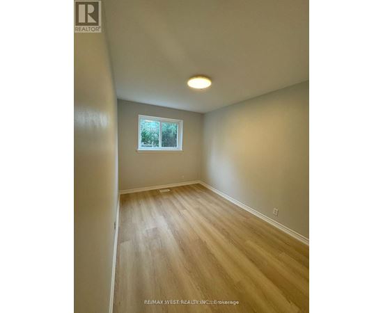 A room with a window and wooden flooring.