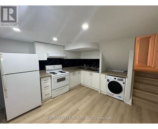 A kitchen with white appliances and wooden floors.