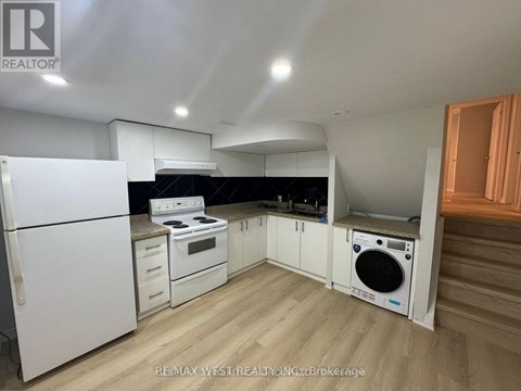 A kitchen with white appliances and wooden floors.