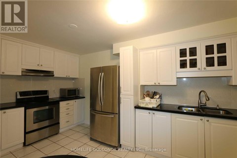 A kitchen with white cabinets and a black counter top.
