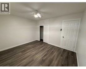 A room with a white door and a ceiling fan.