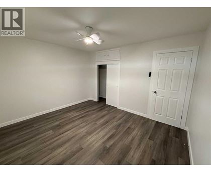 A room with a white door and a ceiling fan.