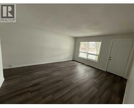 A room with wooden flooring and a window.