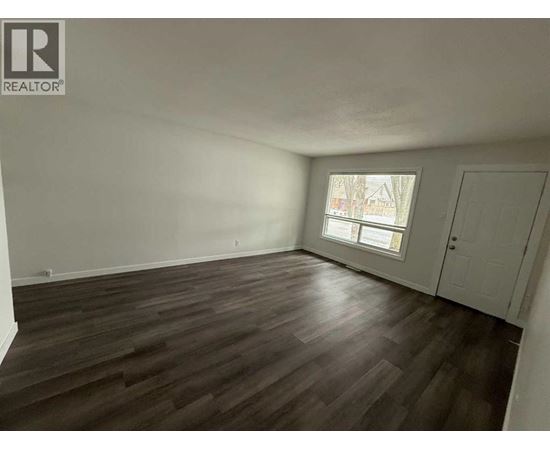 A room with wooden flooring and a window.