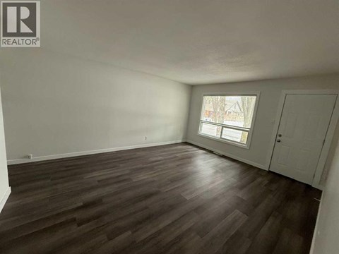 A room with wooden flooring and a window.