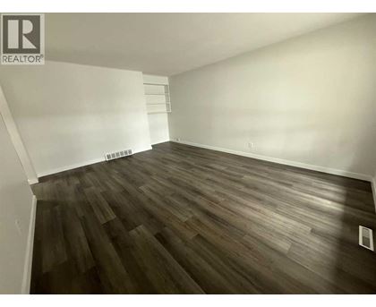 A room with wooden flooring and white walls.