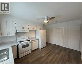 A kitchen with white cabinets and a stove top oven.