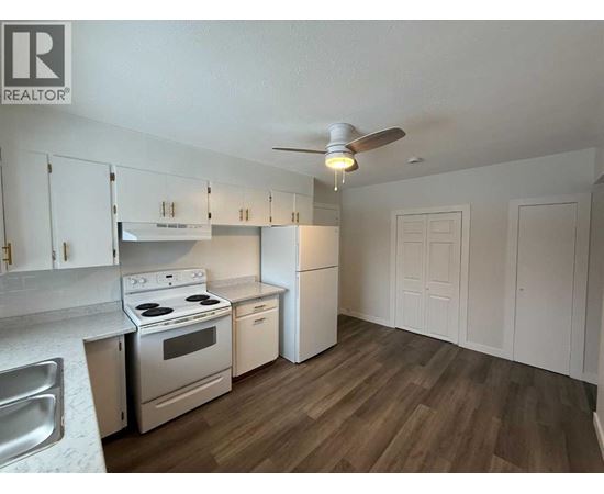 A kitchen with white cabinets and a stove top oven.