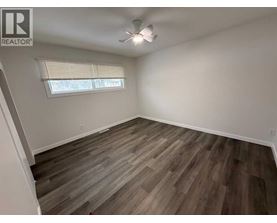 A room with wooden flooring and a window with blinds.