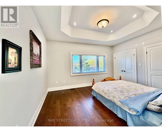 A bedroom with a bed, a window, and a painting on the wall.